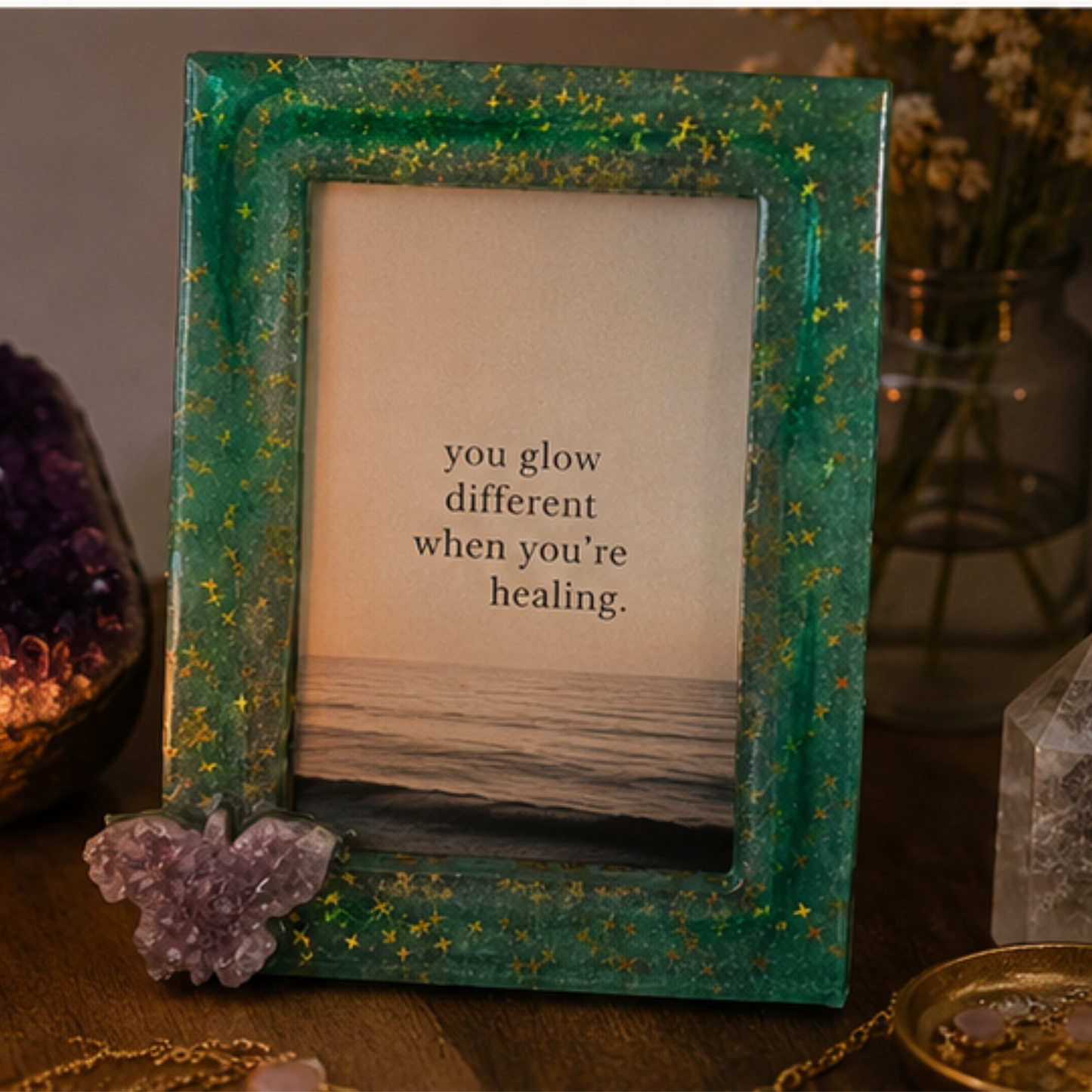 Suggestion
Framed quote 'you glow different when you're healing' with decorative elements on a wooden surface. Green with stars picture frame with a amethyst butterfly