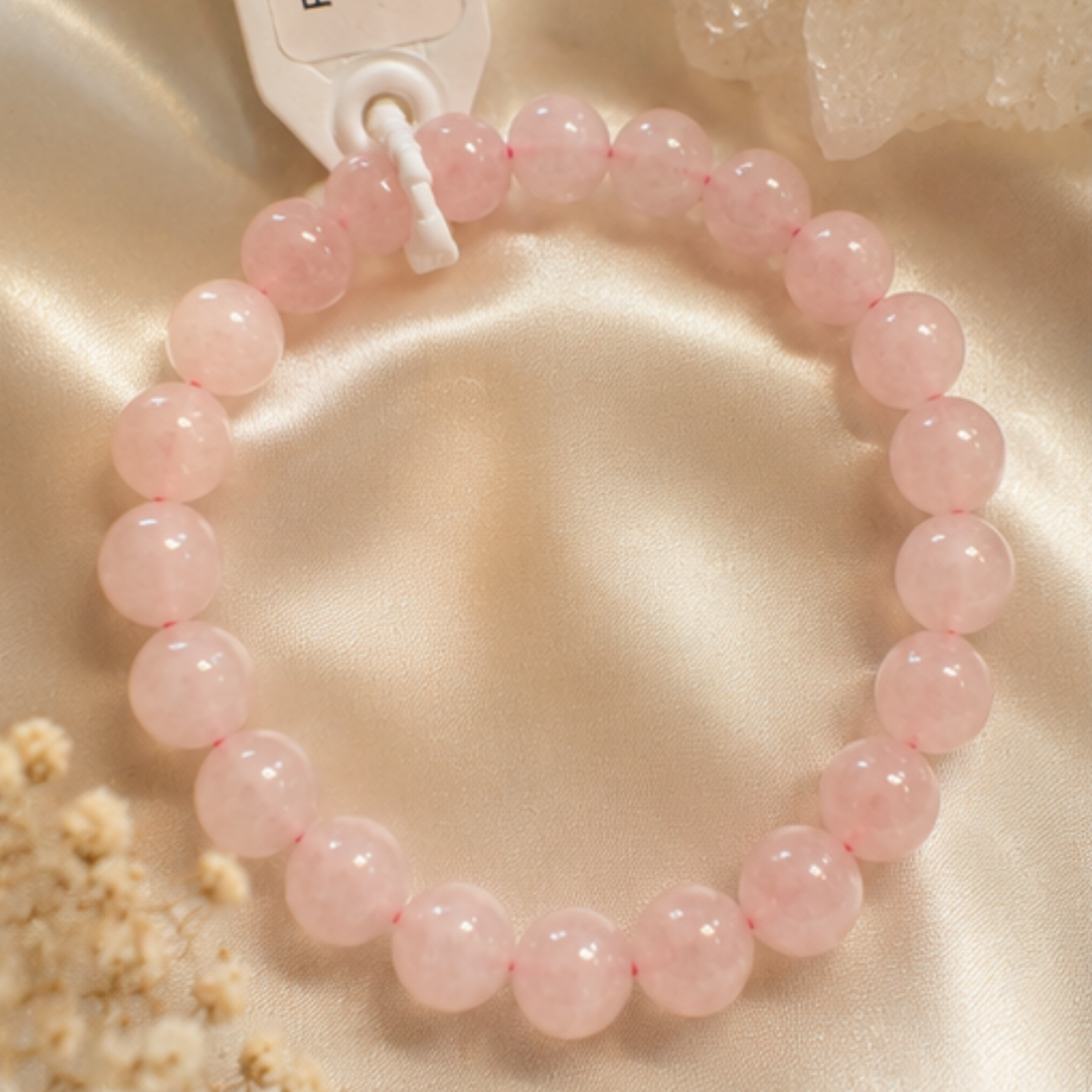Pink rose quartz beaded bracelet on a beige fabric background